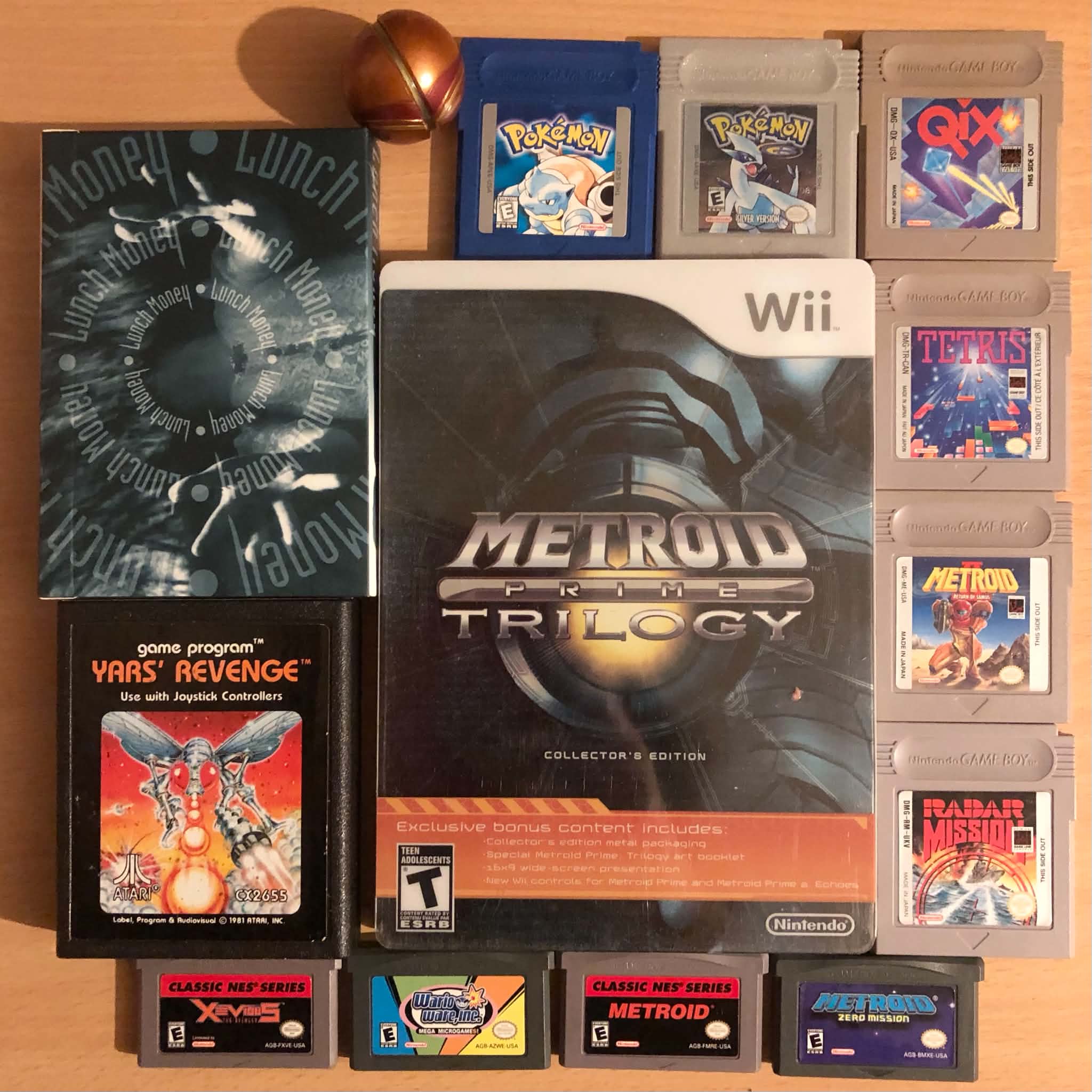 A selection of gameboy, wii, atari, and card games, and a small Samus maru mari toy.