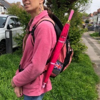 A pink umbrella clasped to the side of a backpack