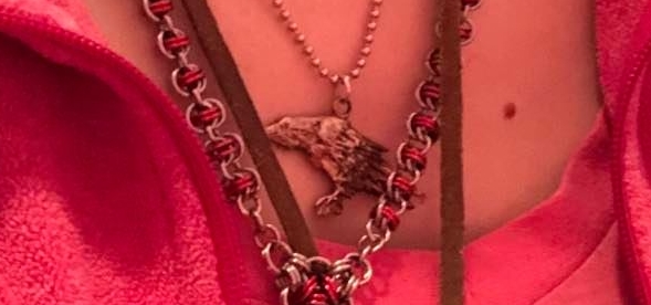 My Pagan Crow pendant. A closeup of the crow with several other chains and straps being worn as well.