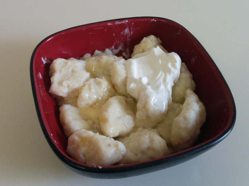 A big ol' bowl of kopytka with sour cream.