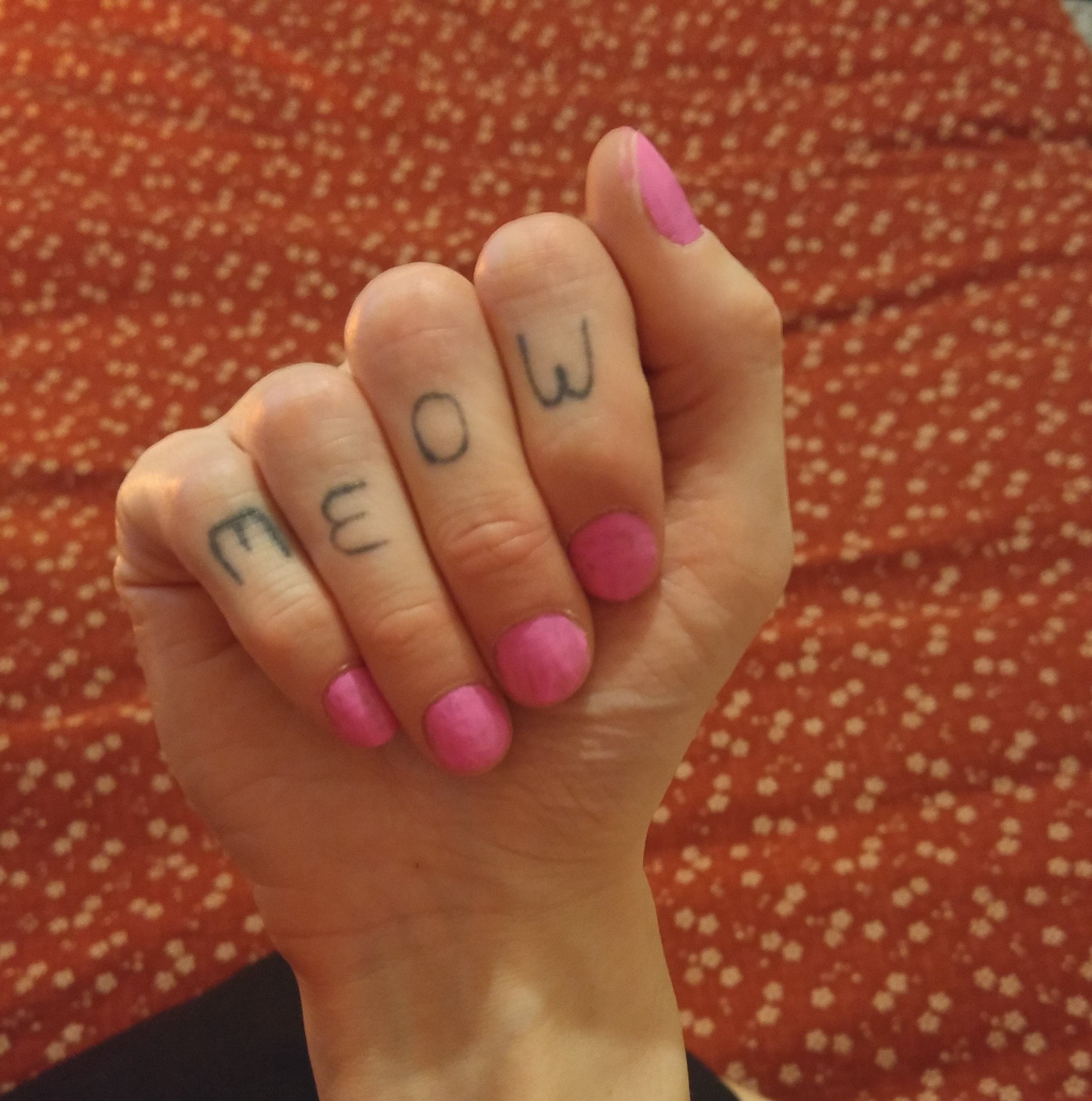 Kabutroid's right hand with the word meow tattooed on the fingers