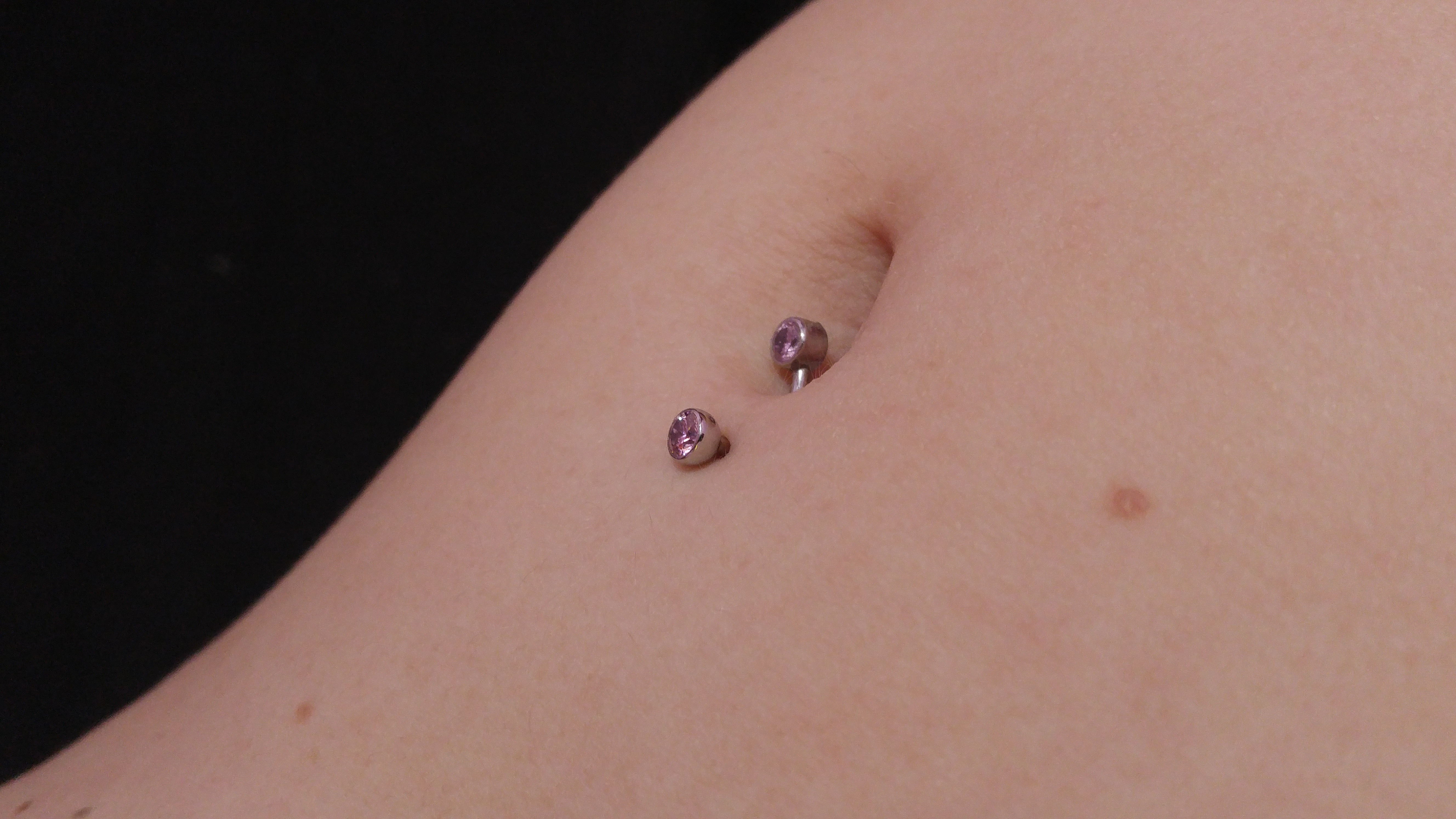 A closeup of the piercing, in Kabutroid's navel
