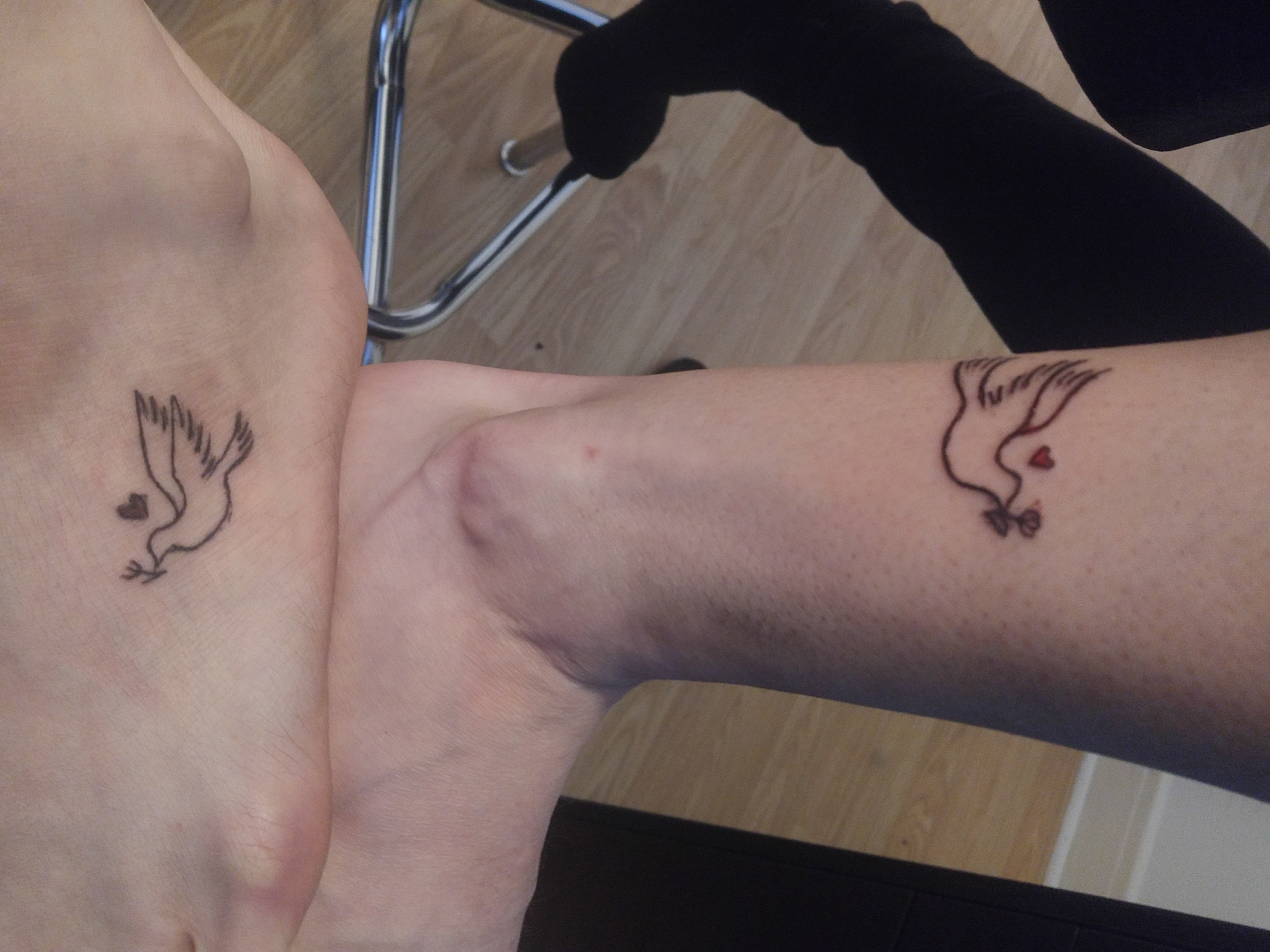 Jo-Ann and my own feet pressed together, showing our tattooes like a mirror image to eachother.