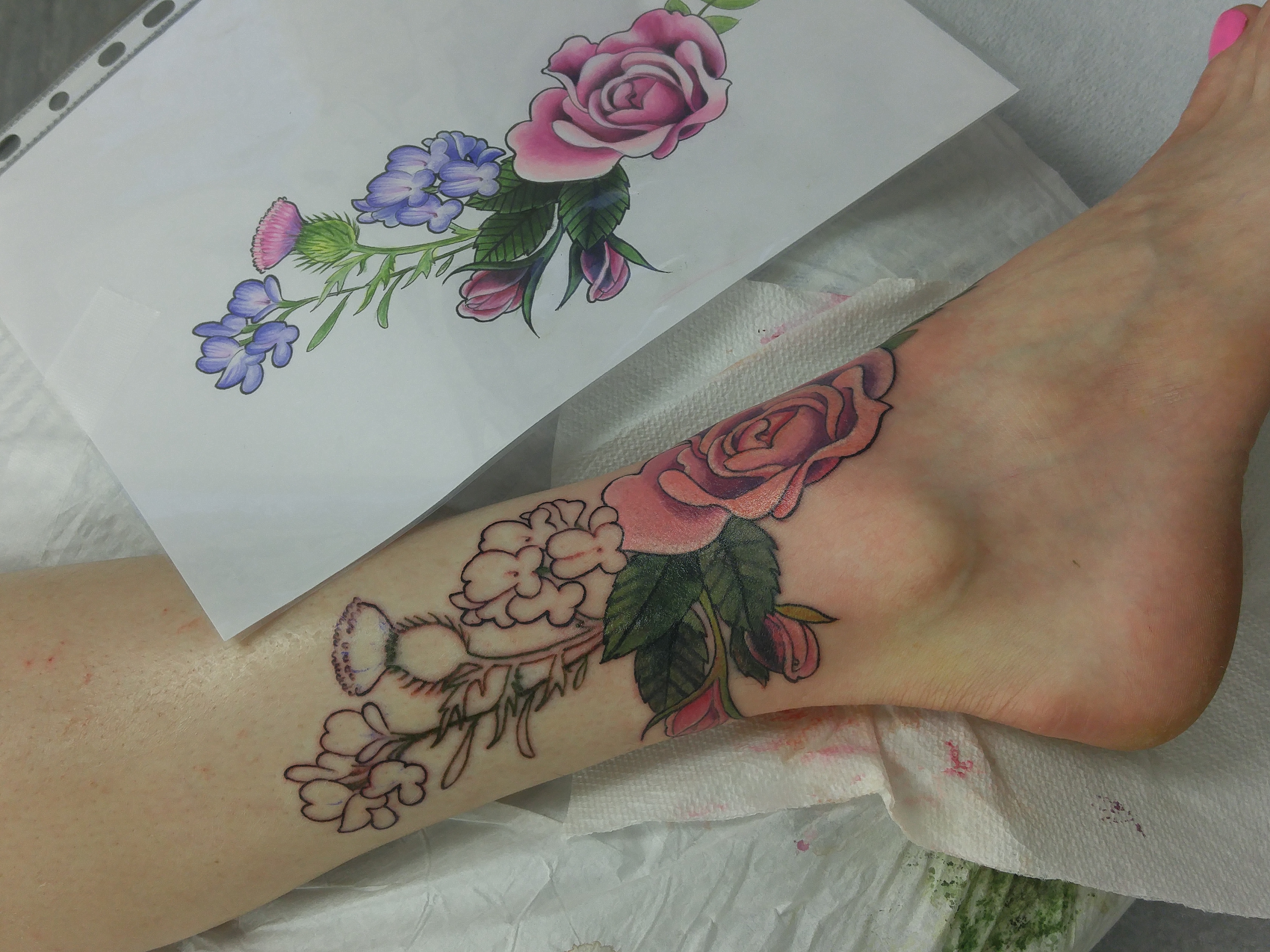 The drawing beside the partially finished tattoo