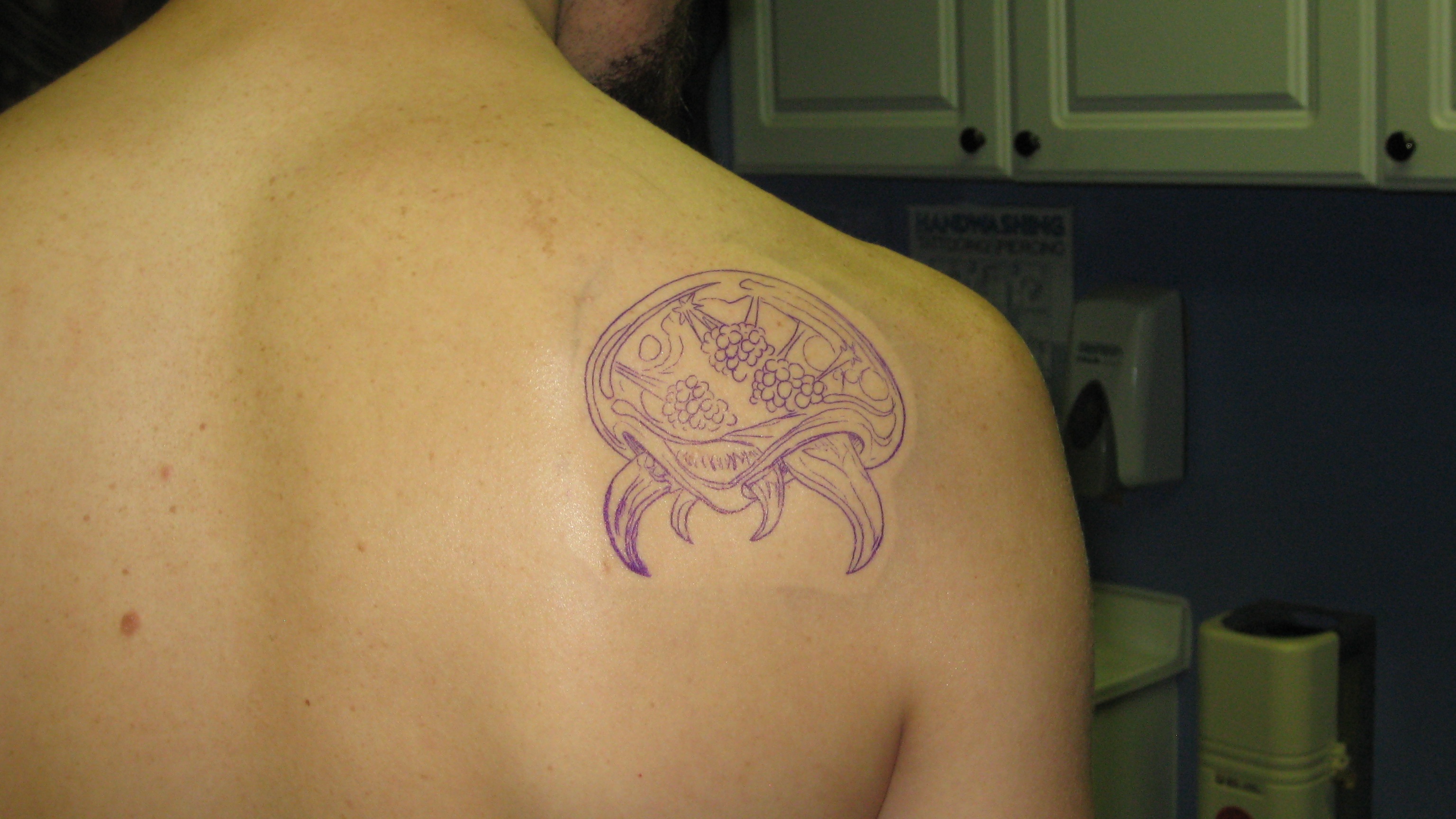 The stencil applied to her back shoulder