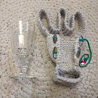 A knitted absinthe cup cozy, with four buttons, and a neck strap. It's quite cheesy.