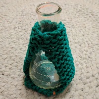 A green cozy around a white erlenmeyer flask