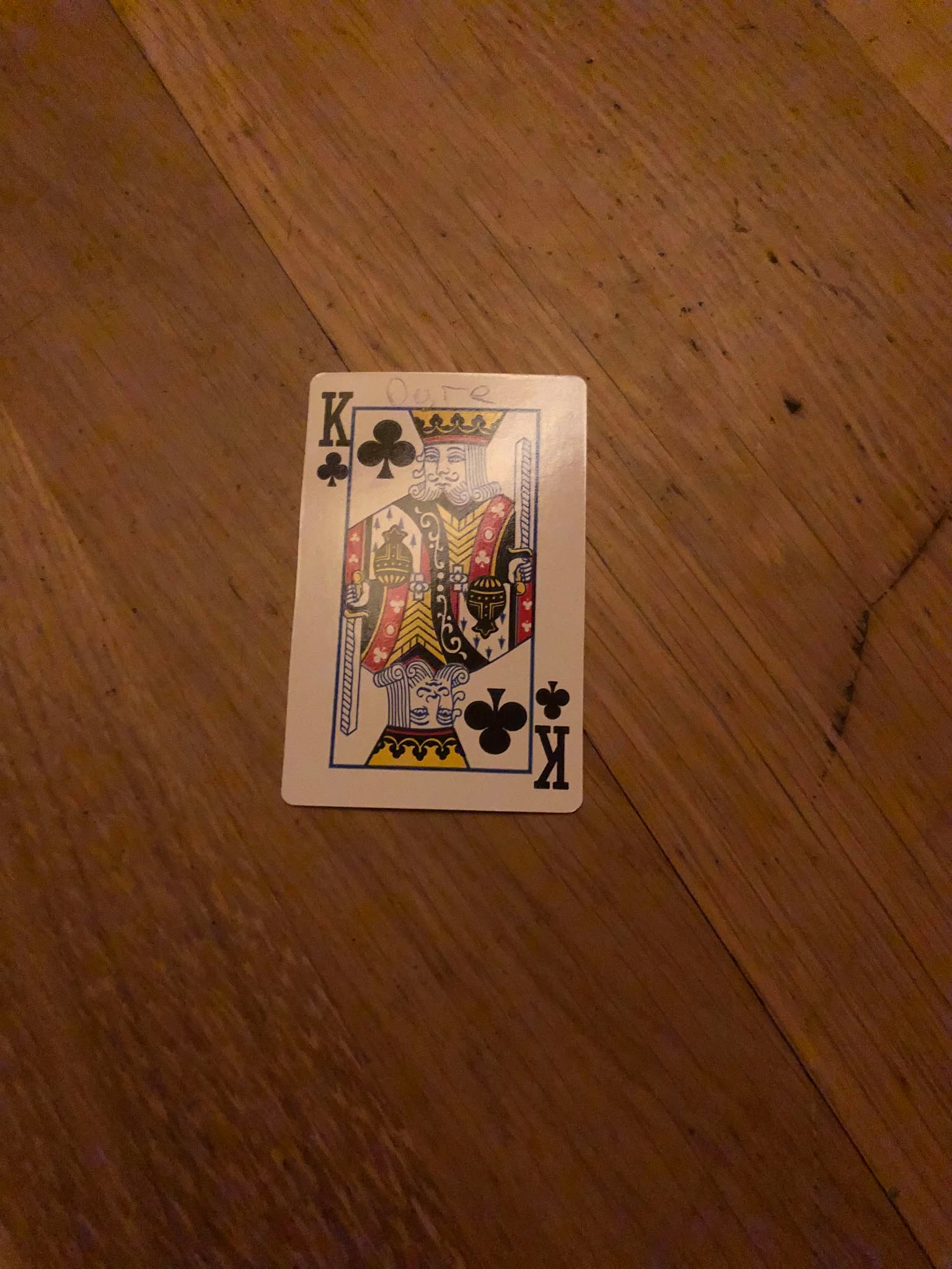 The king of clubs, thrown to the floor in front of the creature.