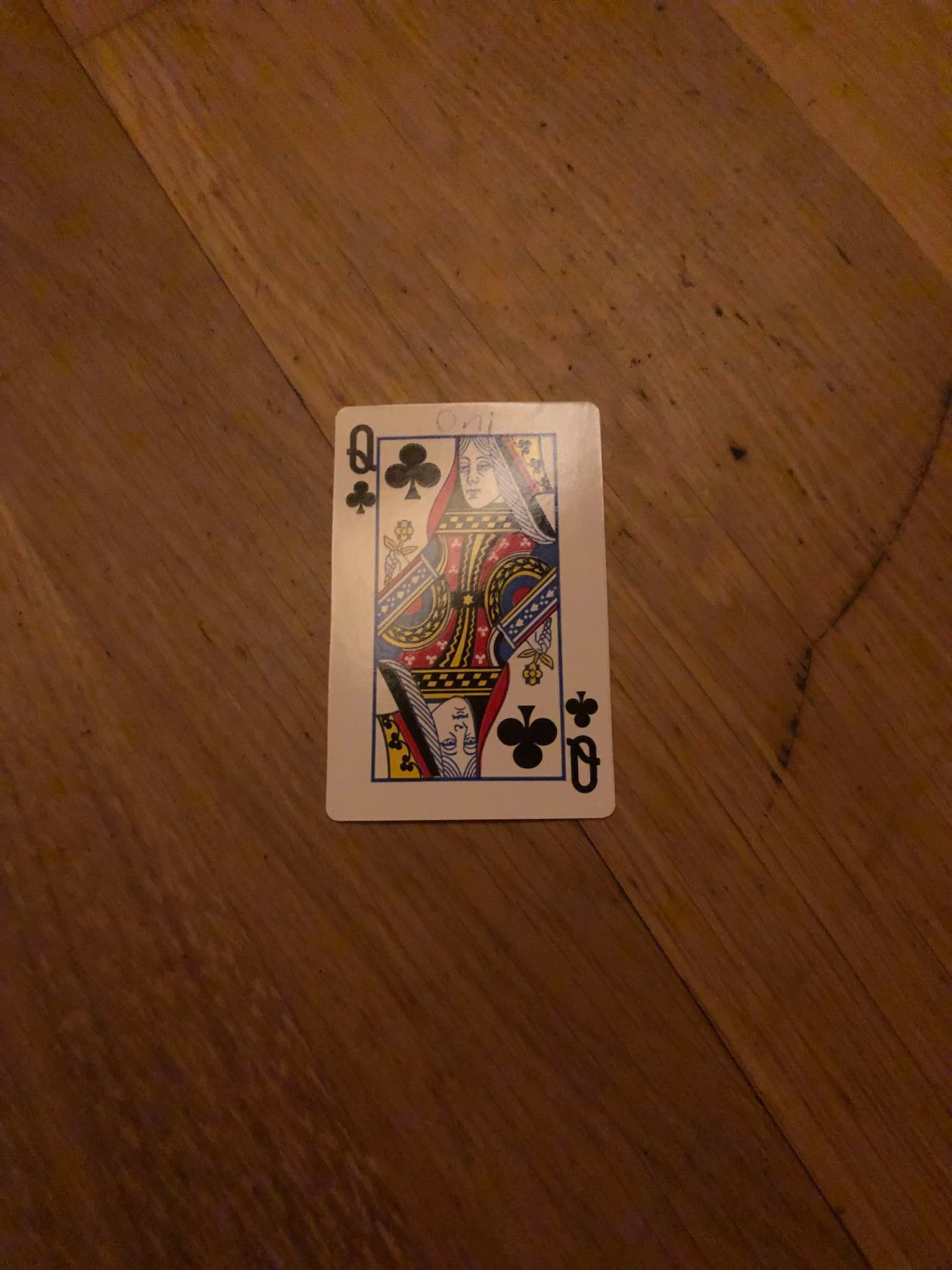 The queen of clubs, thrown to the floor in front of the creature.