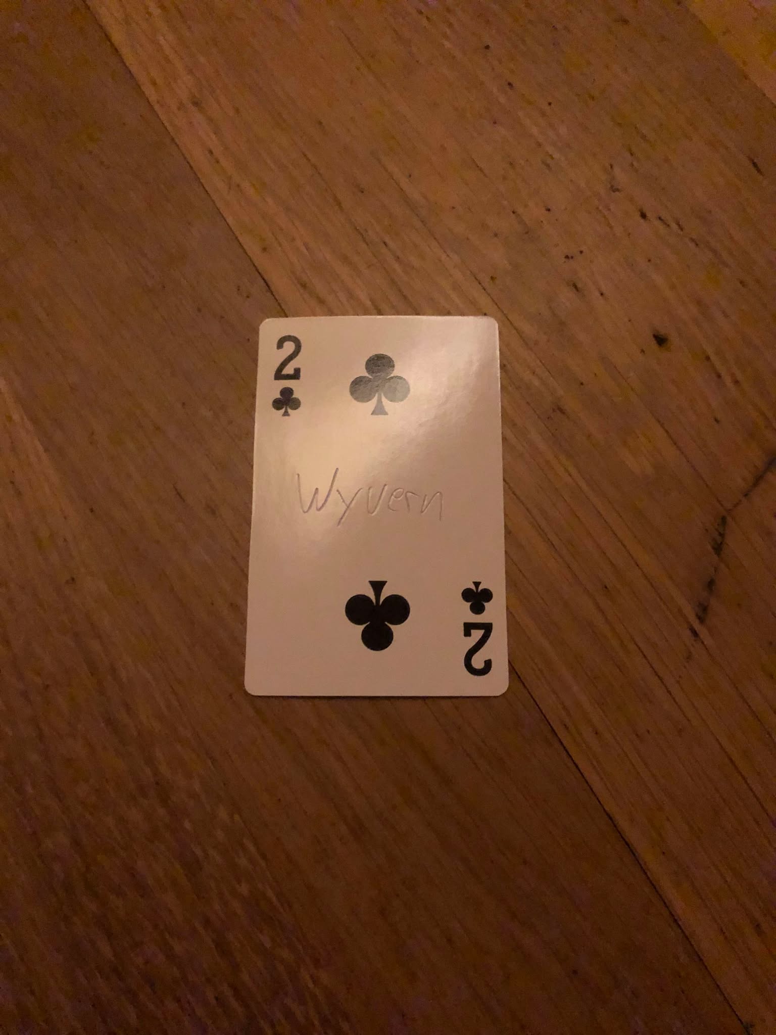 The two of clubs, thrown to the floor in front of the creature.