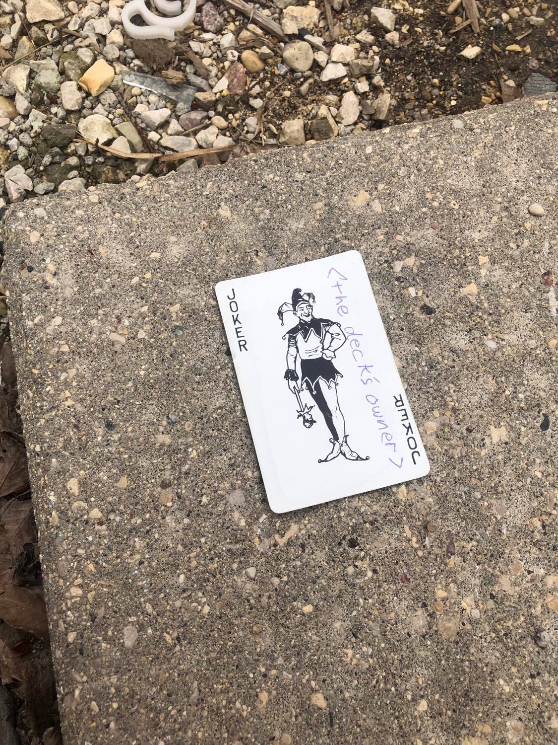 The joker, laying on the ground before the creature.