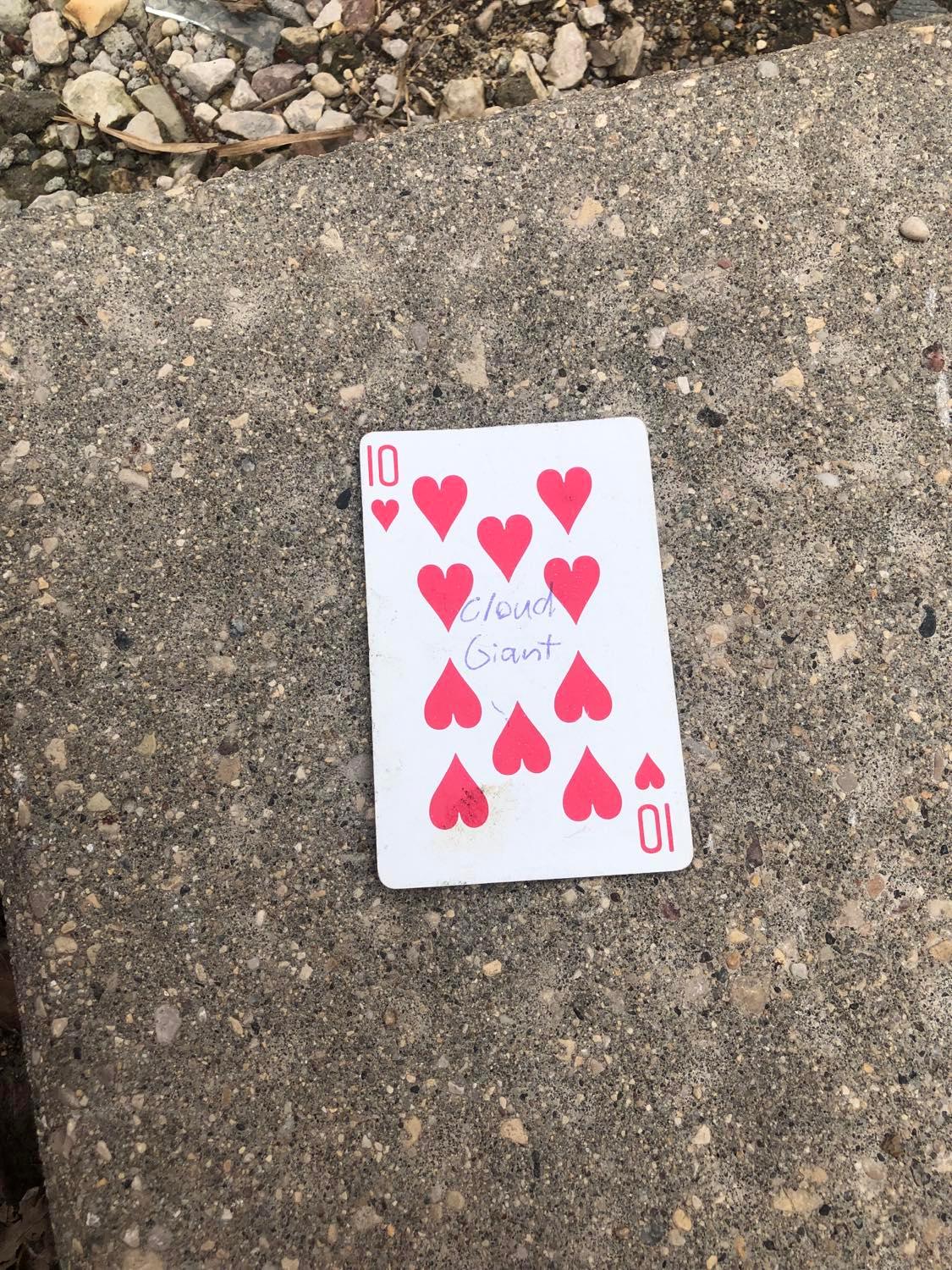 The ten of hearts, laying on the ground before the creature.