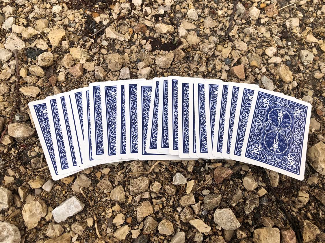 The cards spread out loosely on the path in front of you.