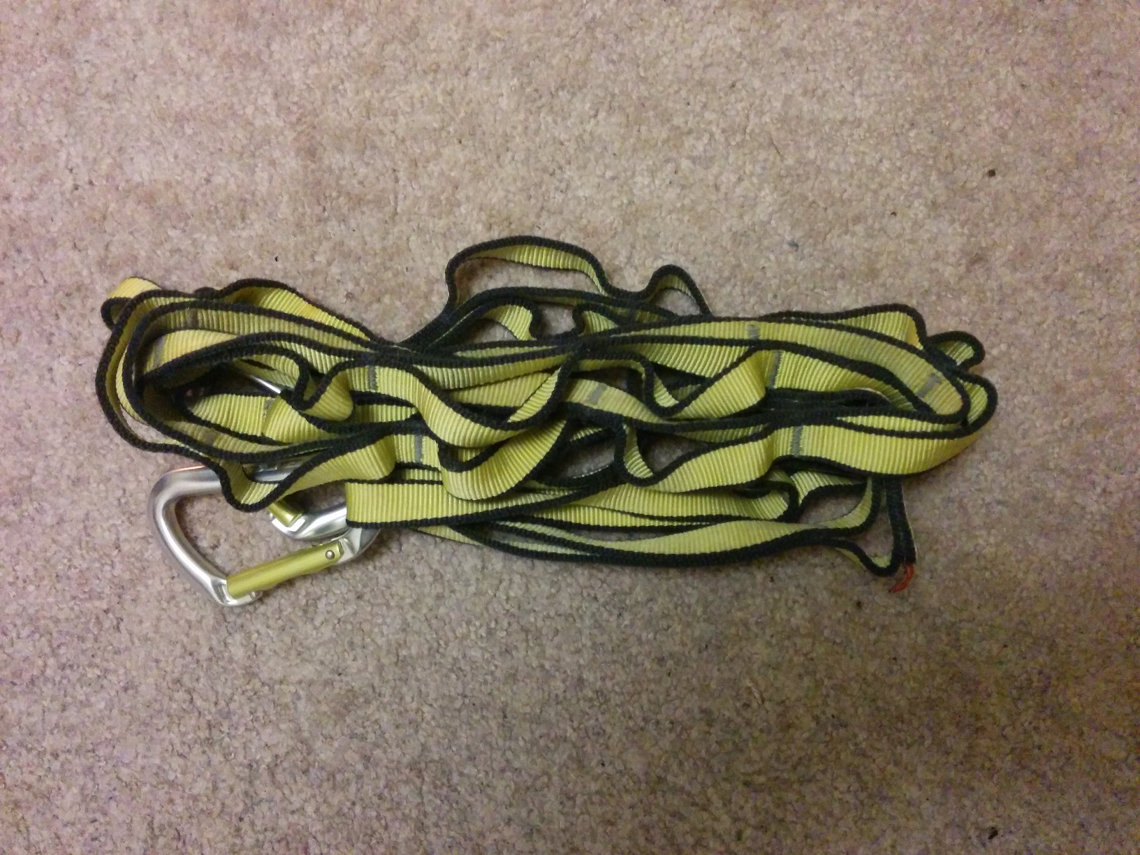 The yellow straps, with caribiners still attached to one side of them, folded over several times into a small bundle.