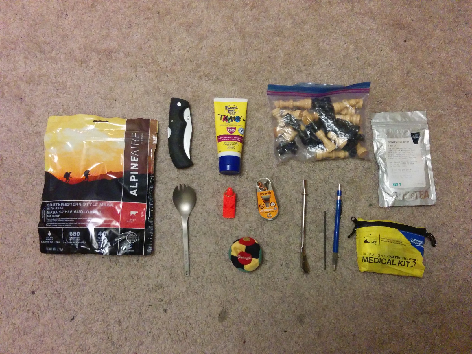 The contents front pocket, spread out neatly on the carpet.