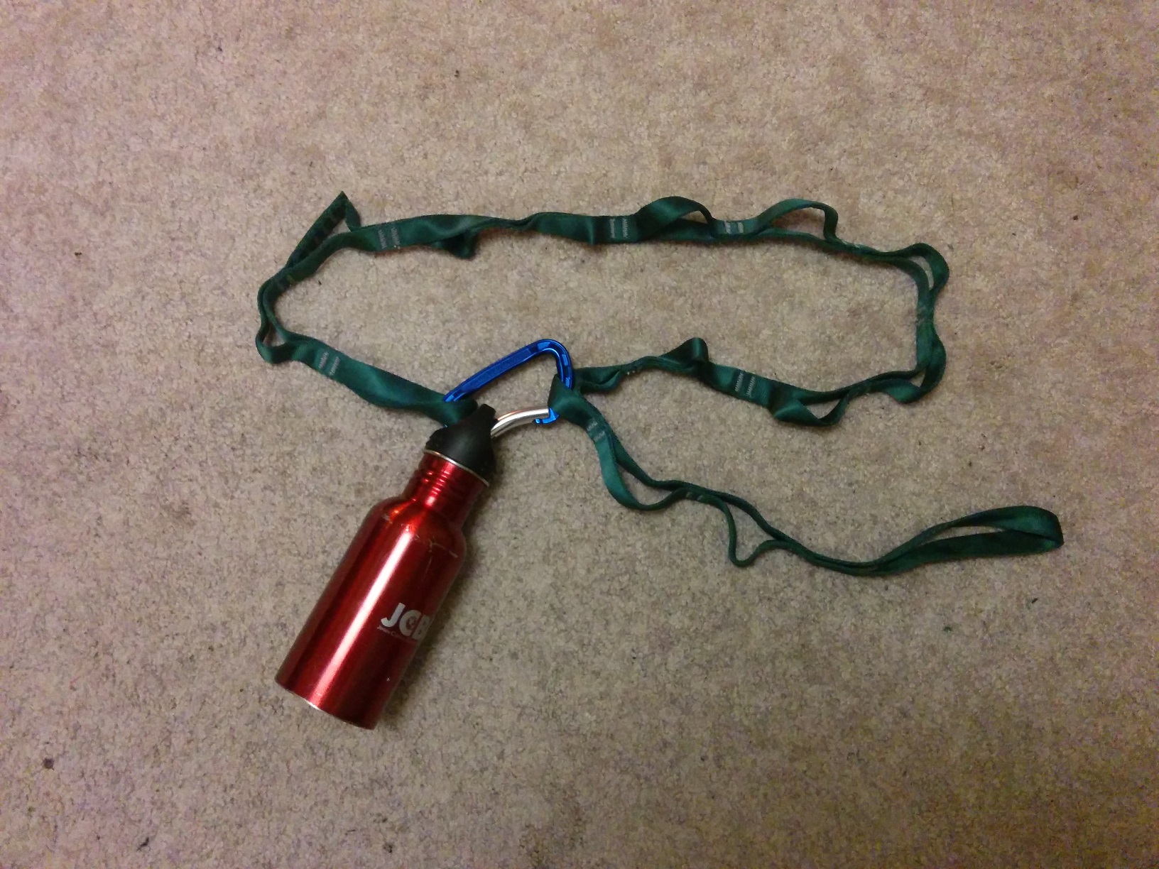 And finally, a metal water bottle on a third daisy chain, green this time, sitting on the carpet.
