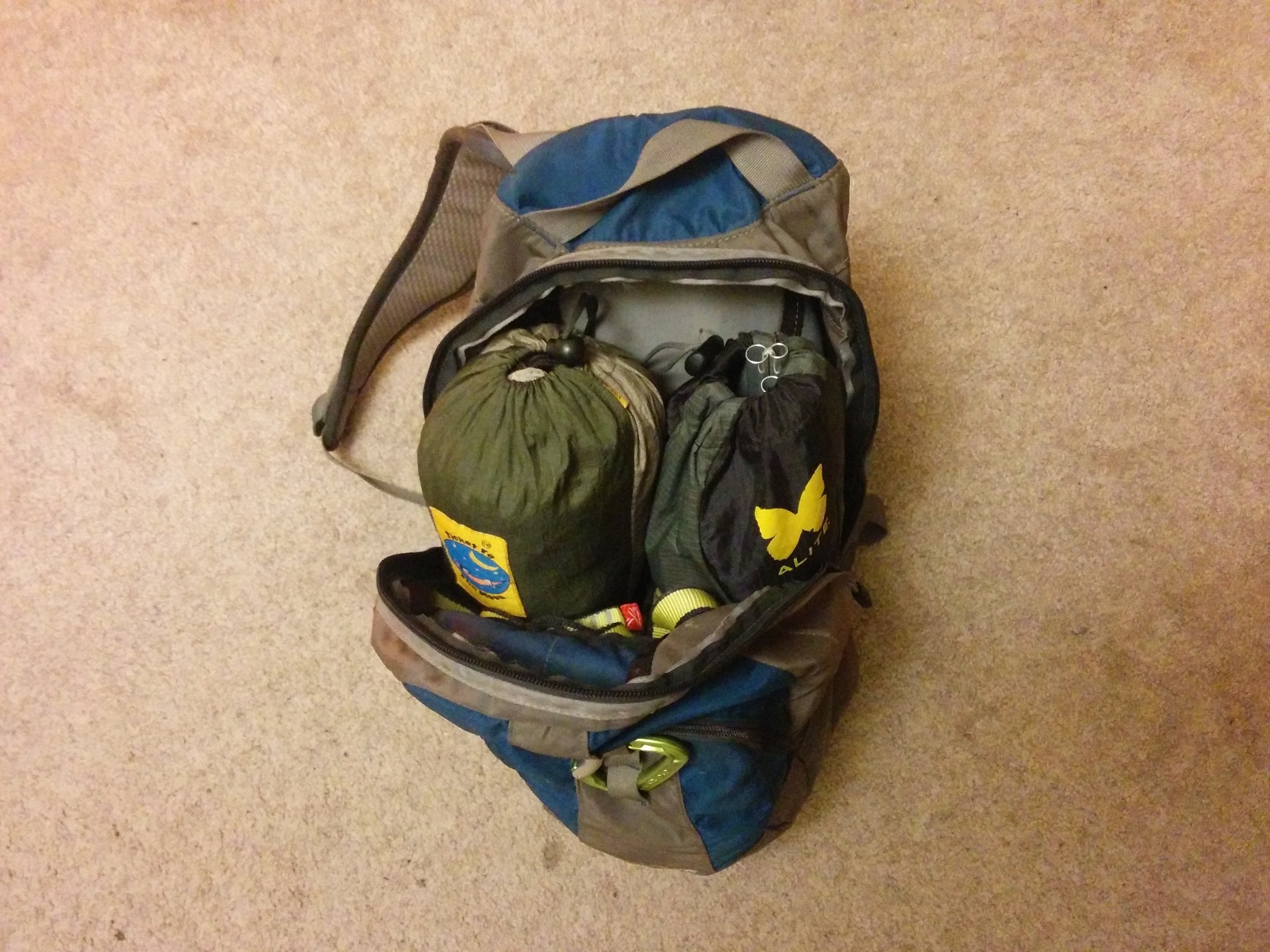 The backpack standing up and open, showing the contents stuffed inside.