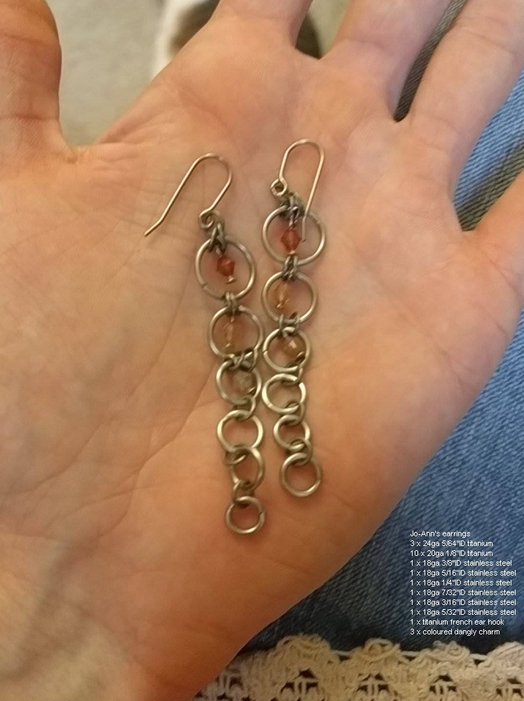 A string of slowly shrinking rings, with a rose coloured bead in the middle of the upper rings.