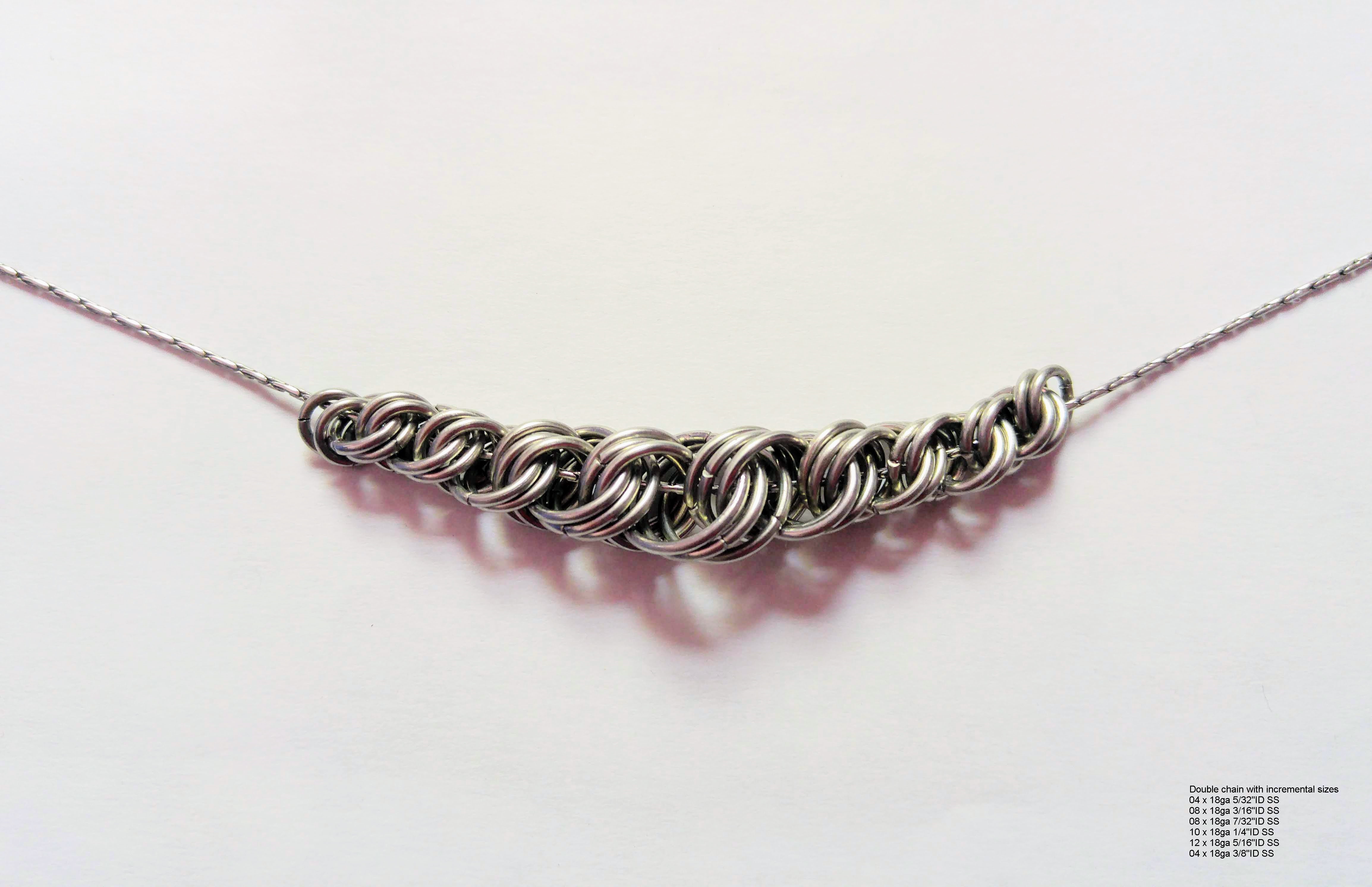 A necklace with the centerpiece being doubles and triplets of gradually growing rings, which then shrink down again on the other side.
