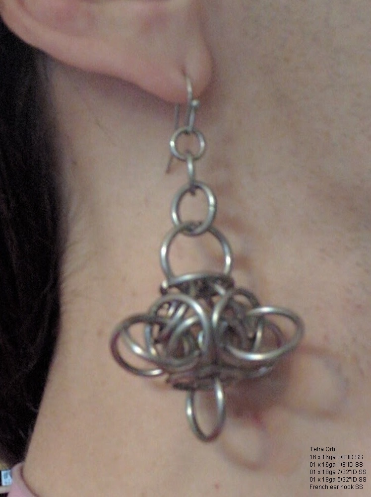 An orbular chainmaille ball hanging from an earring chain.