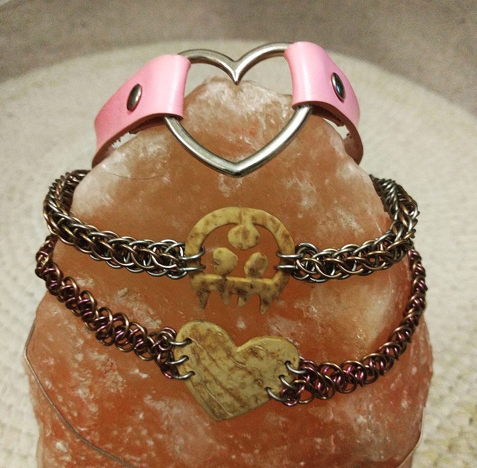 Three collars, one vinyl and two chainmaille, resting on a himalayan salt lamp