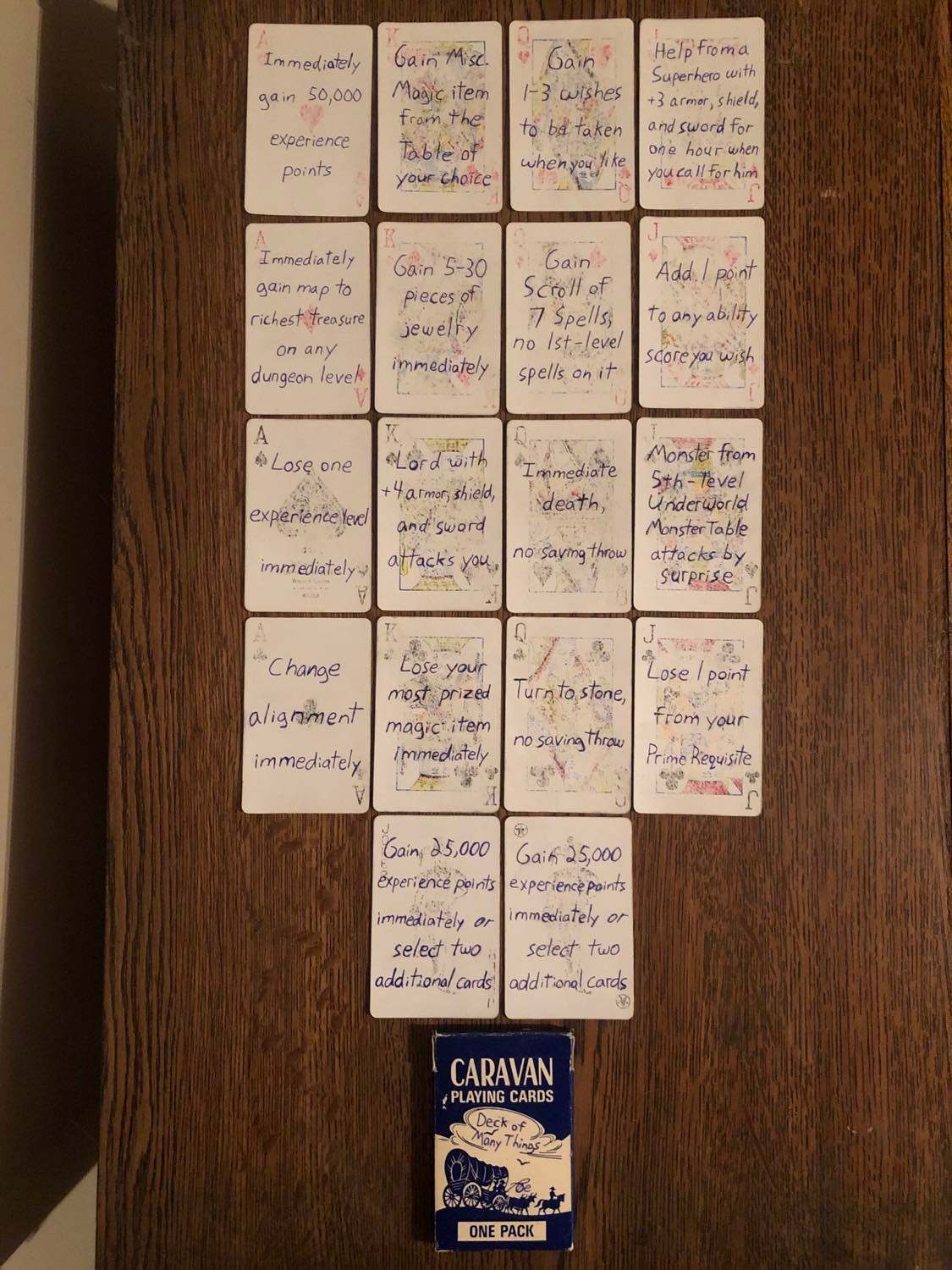 All of the cards laid out, four in a row, each suit, followed by the jokers and then the box. All of the card faces are mostly erased, though you can stil see what card it was. The text for each card is written in bold lettering, as mentioned throughout, and it's just a very tidy looking image.