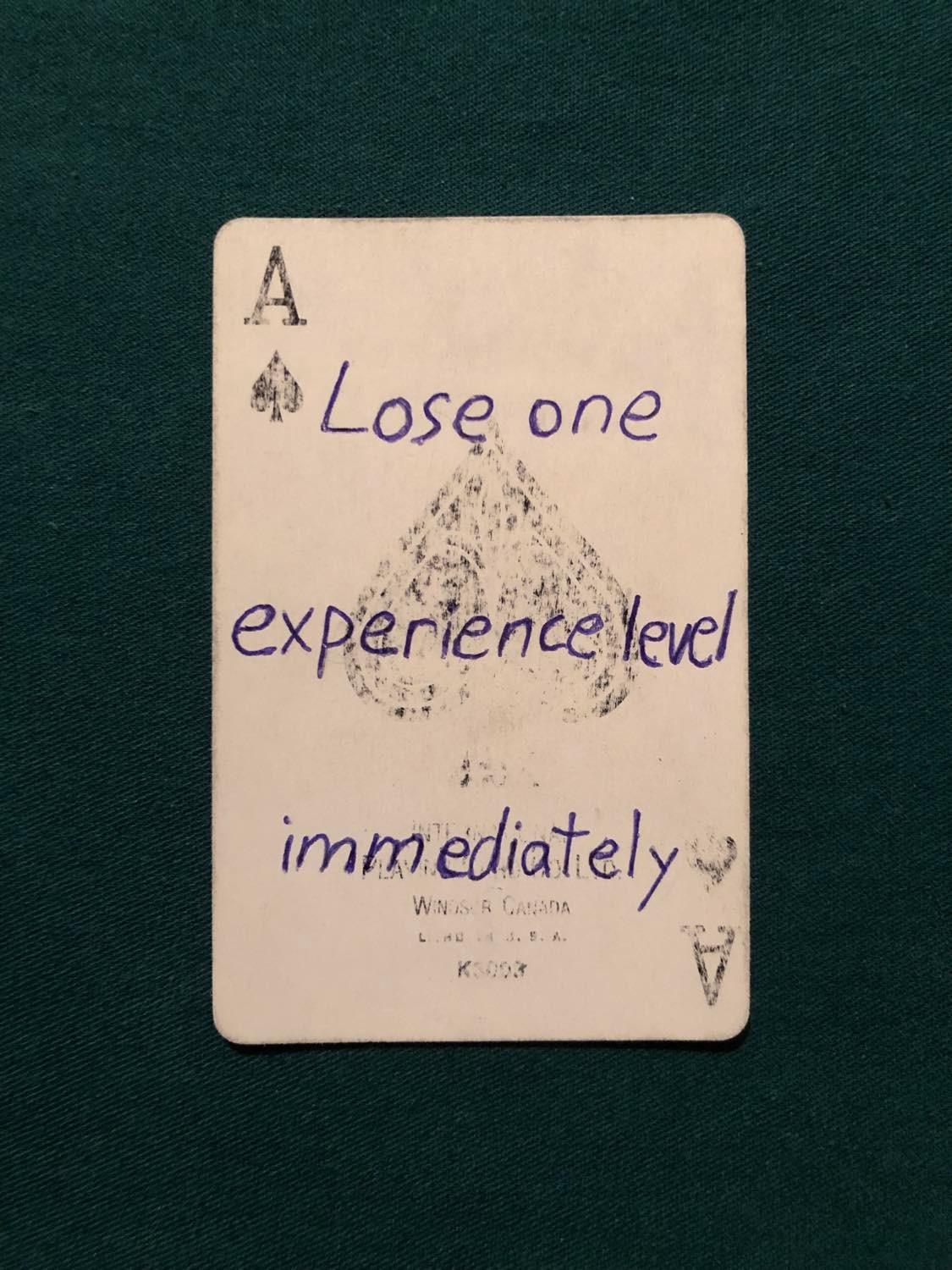 The ace of spades, laying on a green fabric.