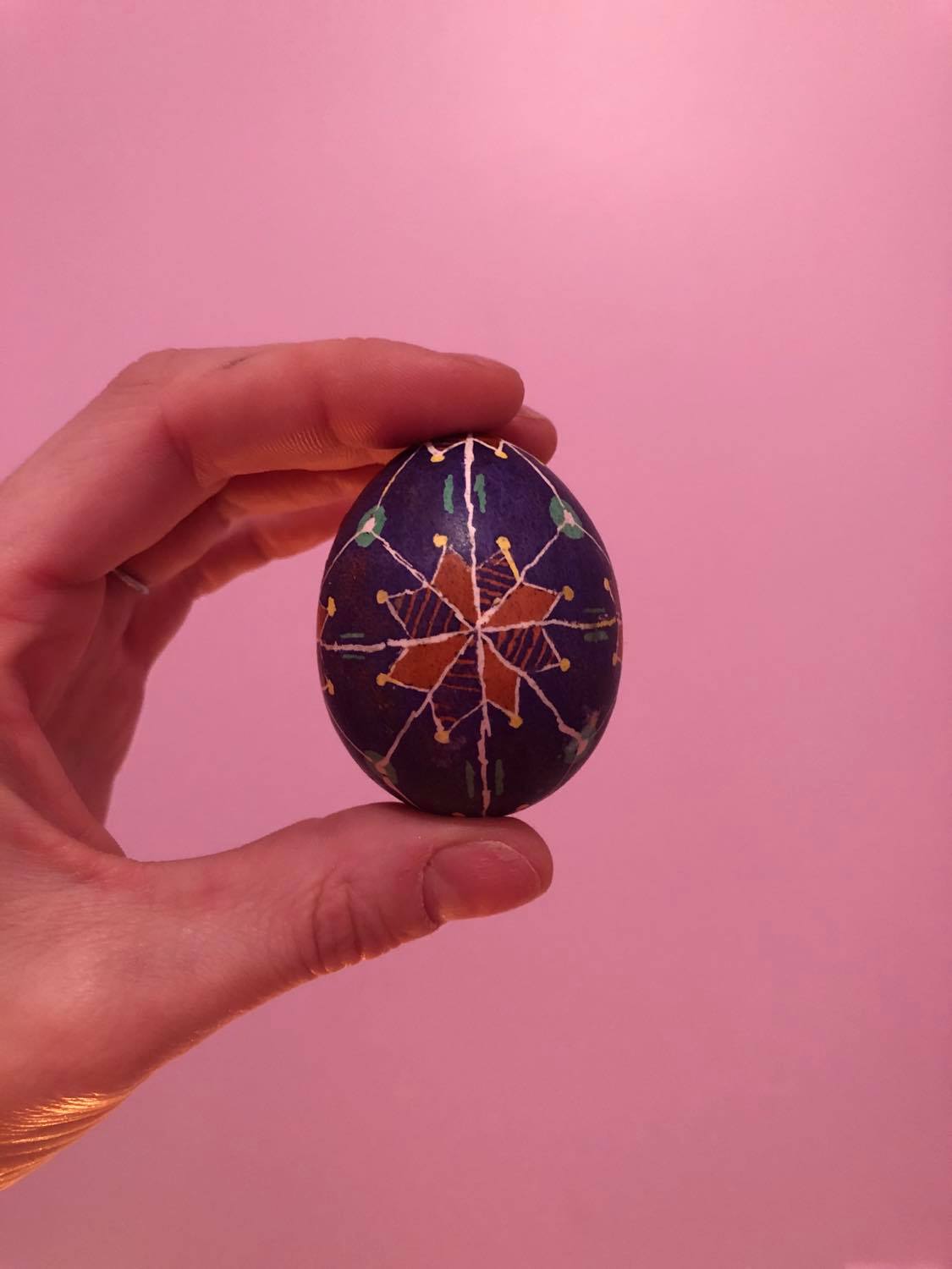 An egg with a purple background, and a star shape in the middle, alternating orange and striped purple, which the unfinished egg turned into.