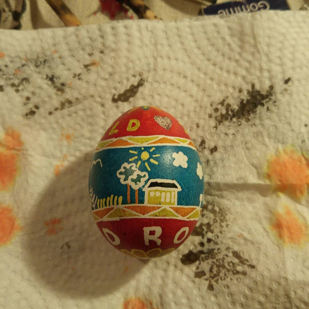 The house in Landmark, on the side of an easter egg, with blue sky and red tops and bottoms of the egg, giving the names Zilberfeld and Red Rose.