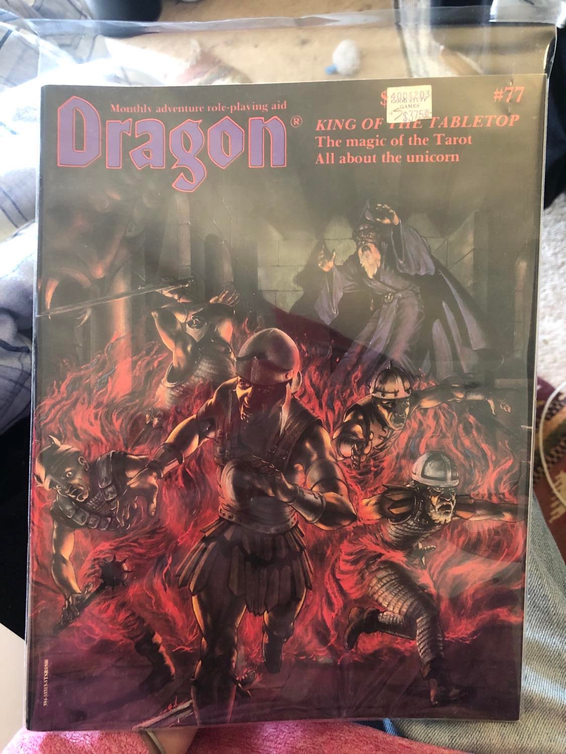 Dragon magasine issue 77, the one with the tarot of many things. It's inside of a plastic sleeve... don't expect it to stay there lol, I'm not that type, besides it's not A++ or whatever, some minor scuffing. Like it's in *ridiculously* good condition, like if this is not a reprint (I'll check it one day, no worries either way), it must have sat on a shelf in a bag its entire life. Like the pages aren't even creased open, I dunno. If this thing's original... well to be (yah let's prattle to you a bit) honest I doubt that it would get to more than a few hundred dollars, there are lots of copies of it, and I paid thirty dollars for it this year in 2022. D and d is getting really big these days, so it could become more valuable, you never know. There's no text saying it's a reprint, and it appears that there's so many available right now, how obscure this presently is (there are very few articles or even forum posts talking about it), but it might take off. Still, I don't expect to keep it in that plastic sleeve, it's got some minor minor scuffs, like A+ but not A++ type of thing. Firm cardstock paper all around, a solid magasine. I plan to keep it open in my d and d box personally, let it get scuffed and scratched a bit, get lived in a little. Nah, I'm not a keep it in the box kinda person, I've gotta play with it. 200 dollars to... well like I said, it's not A+++ material, so if they ever get to five grand... not that I'd want to sell it regardless, I dunno a mill, but this ain't Superman number 1, three million copies, let's let this thing live a little bit. You've got a minor scuff, I'll give you a few more. I mean it's got insect comics (see pic three), I've *gotta* play with it. If you're unfamiliar with the insect note, see my fly chronicles page, I've befriended them. Anyways yes, the cover of dragon magasine 77, with the price tag on the cover still, 3.75 from good stuff games. OOhh, you got a minute, I'll lay it out here. Dragon, King of the tabletop. The magic of the tarot. all about the unicorn. monthly adventure role-playing aid. 77 is at the top right. A wizard at the back of a stone chamber, archways and pilars all around, a giant fanged stone head on the left. He looms behind a gathering of soldiers, all engulfed in fire, running away in fear and confusion. It's very atmospheric, the pale green light of the back of the chamber. Yah those soldiers should have had a cleric with them, or... I dunno, they seem woefully unprepared to take on a wizard, I don't know what they were thinking. Like... miles away, they should have seen this coming, I dunno what the story is behind this lol. They should really have a cleric with them, these are all fighters, c'mon guys. Some have beards, that fang face is glowing kinda cool. Yah guys, come back with a cleric, or if the wizard is the good guy well then... wow, easy win. Anyways, it looks cool.