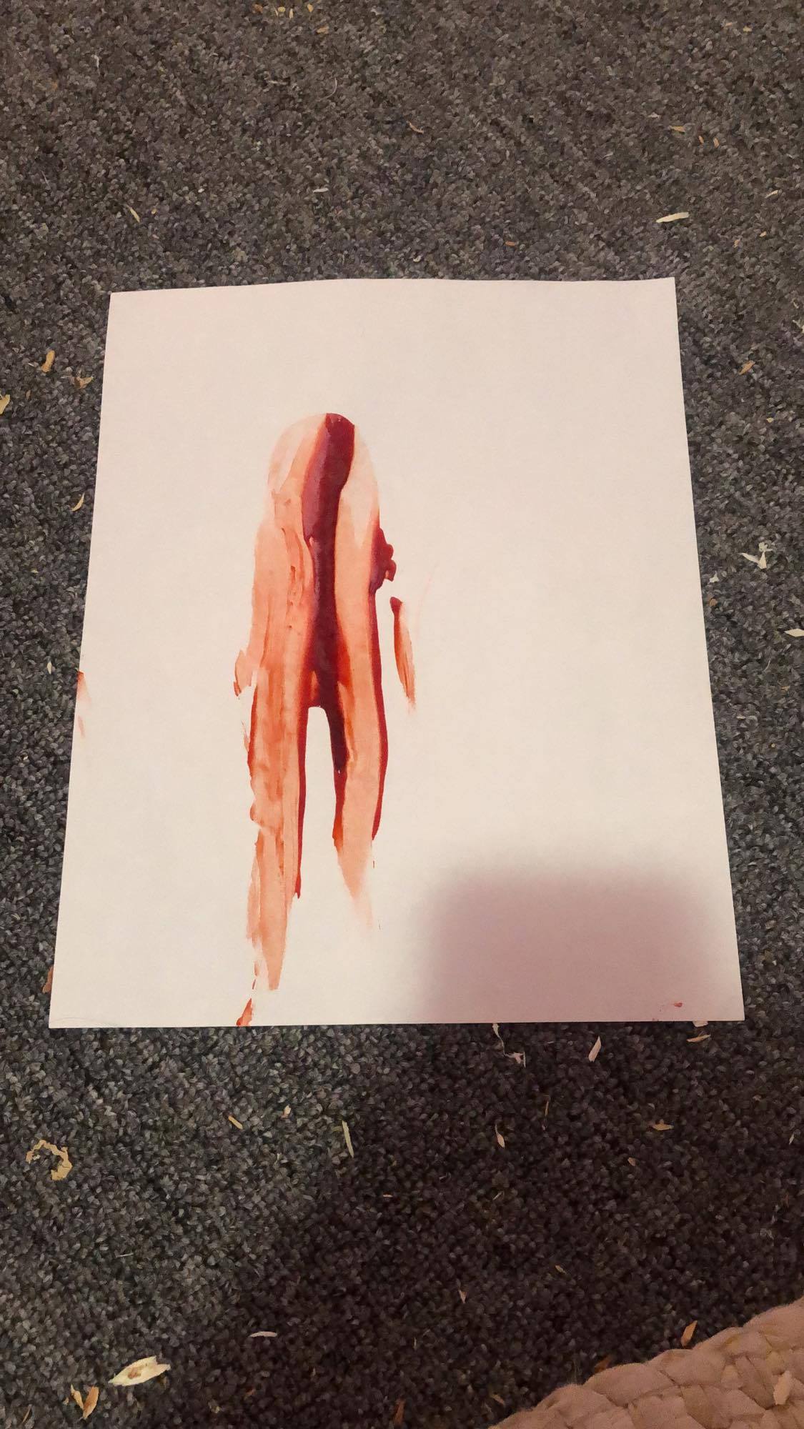 Blood pulled down a canvas to look like a lonely figure.