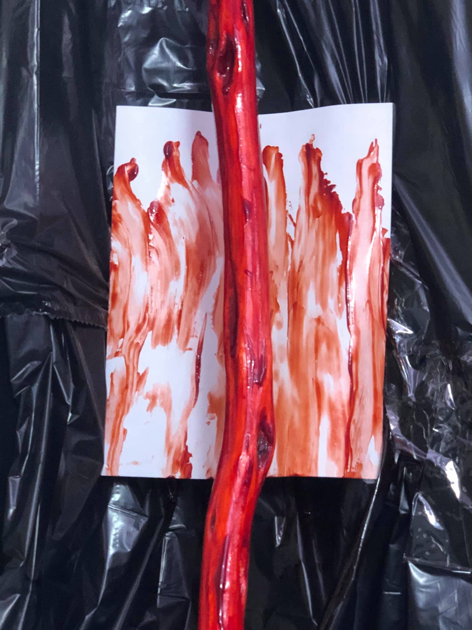 The middle canvas, showing multiple smear lines of blood down the canvas. The staff in front of the canvas loos a bit like a blood covered bone.