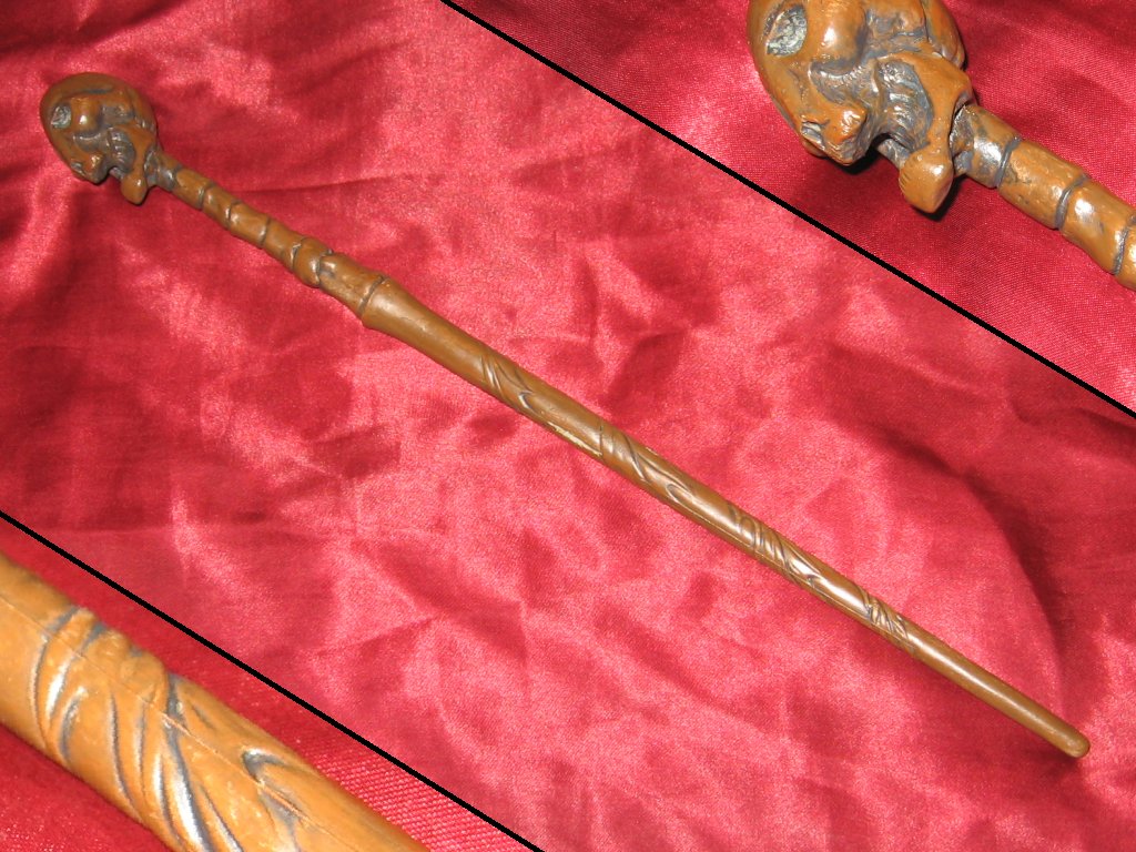 The original wand, on a red surface, with closeups of the origina leaves and skull on the wand.