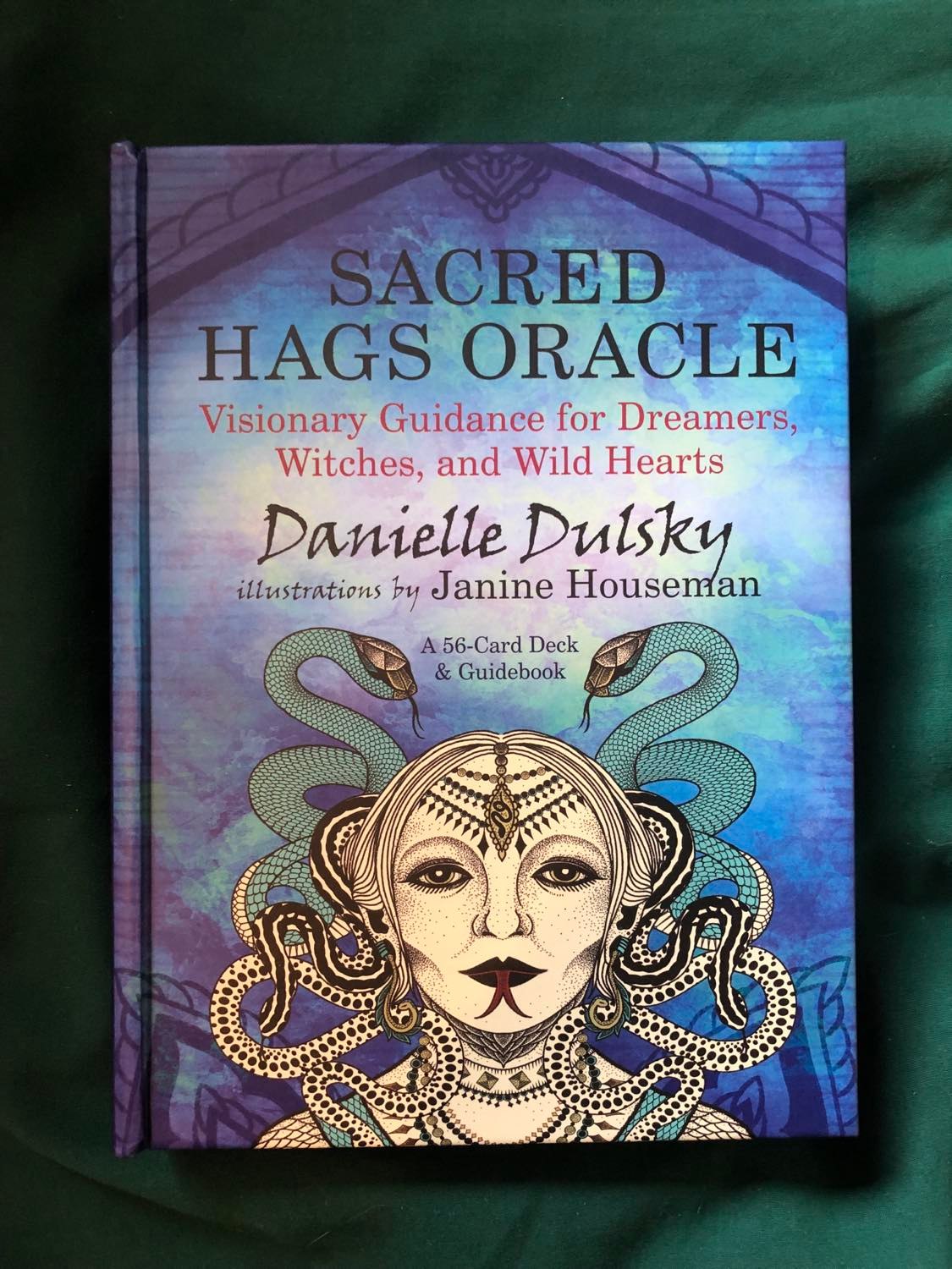 The box for the Sacred Hags Oracle, sitting on a green fabric surface.