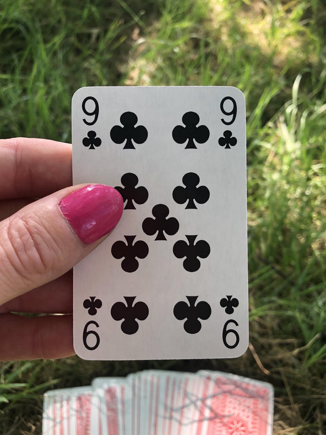 The nine of clubs, held up from the drawn out cards.