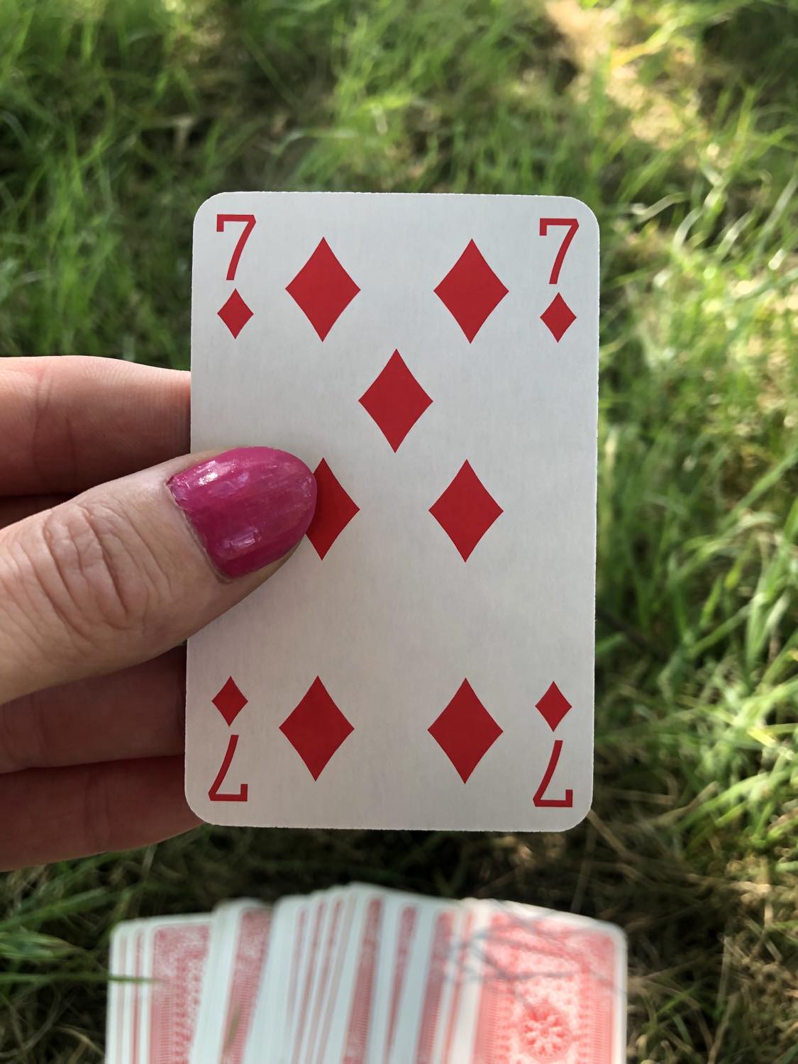 The seven of diamonds, held up from the drawn out cards.