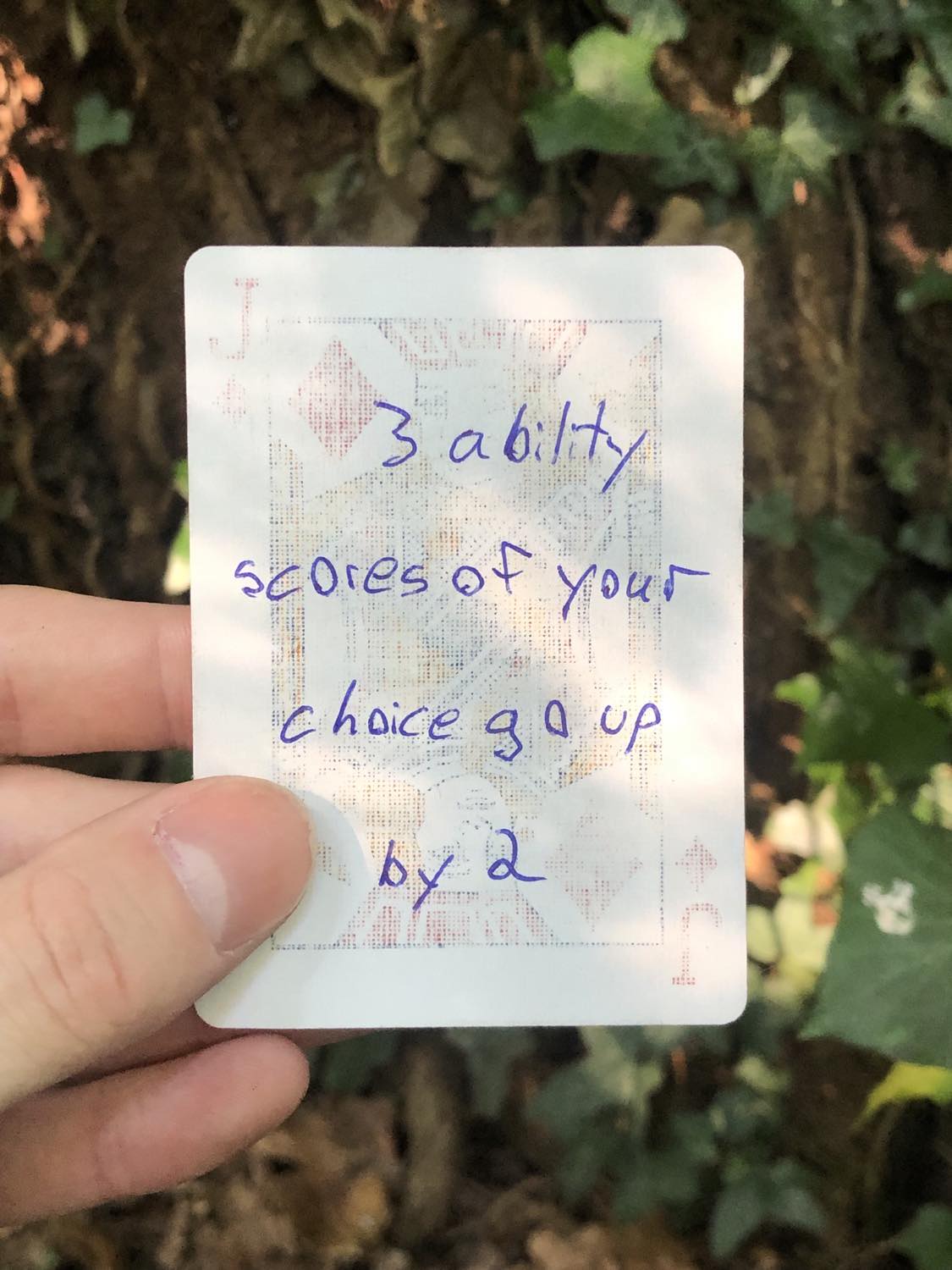 The jack of diamonds, held above the detritus on the ground. 3 ability scores go up by 2.