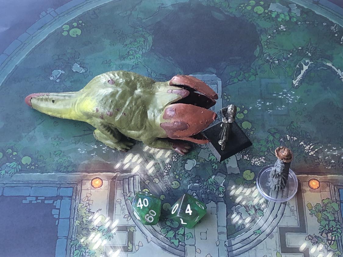 The battle map from above, with the monk fully attacking the creature, and the sorcerer rolling a pair of d10 dice to determine the wild magic surge.